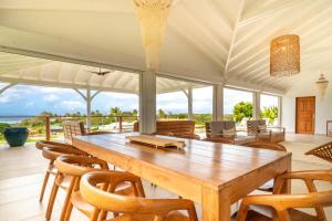 a large dining room with a large wooden table and chairs at Villa Joséphine in Grand-Bourg