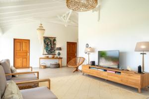 a living room with a tv and a couch at Villa Joséphine in Grand-Bourg