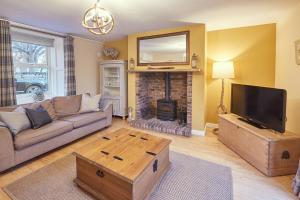 a living room with a couch and a fireplace at Church Cottage by Coast & Country Stays in Beadnell