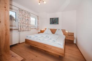 a bedroom with a bed with white sheets and a window at Unterwötzlhof in Abtenau +37 photos