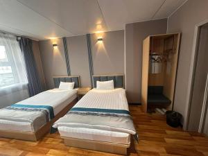 a room with two beds in a room with a window at Mandala Hotel Erdenet in Erdenet +7 photos