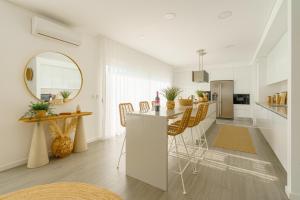a kitchen and living room with a table and chairs at Chill Villa - Signature by Paradise Portugal in Mariquiteira