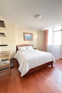 a bedroom with a large white bed and a window at HOTEL IBYZA Ipiales in Ipiales