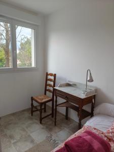 a bedroom with a desk and a chair and a bed at Le Rocher au Thym in Limoux