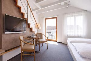 a bedroom with a bed and a table and chairs at Landhaus Müller in Immenstaad am Bodensee