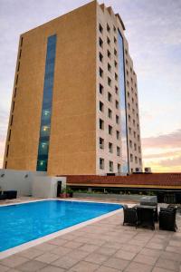 a building with a swimming pool in front of a building at Intercity Tower Hotels in San Pedro Sula