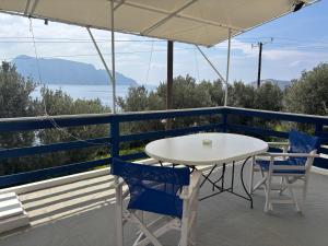 a table and chairs on a balcony with a view of the water at The traditional house-Skalia,kalymnos in Kalymnos