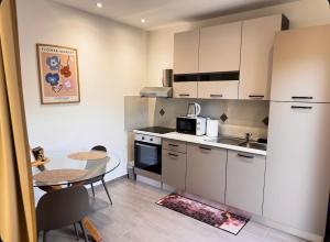 a kitchen with a table and a small kitchen with a table and a tablektop at Studio apartment Lu in Rupa +14 photos