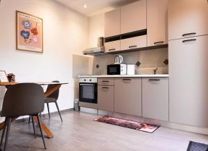 a kitchen with white cabinets and a table with chairs at Studio apartment Lu in Rupa