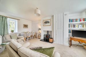 a living room with a couch and a piano at Amys Cottage in Sherborne