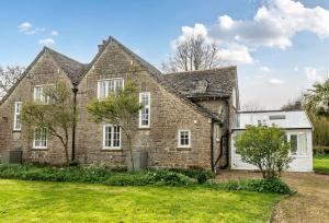 a large brick house with a white garage at Amys Cottage in Sherborne