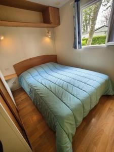 a bed in a small room with a window at Camping 3 étoiles - Piscine - à 2 minutes des plages in Penvénan