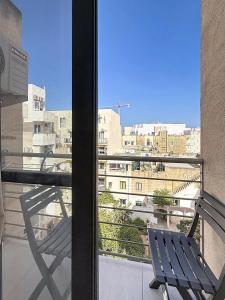 a chair on a balcony with a view of a city at Central Msida Modern Holiday Apartment in Tal-Ħriereb