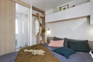 a bedroom with a large bed with pillows at Camping 3 étoiles - Piscine - à 2 minutes des plages in Penvénan