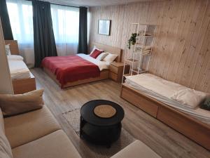 a small room with two beds and a table at City Center Hostel in Mažeikiai