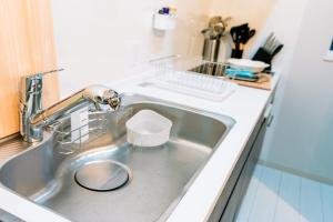 a kitchen sink with a faucet and a bowl at ララリカ in Kami-furano +30 photos