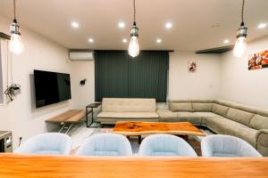 a living room with a couch and a table and chairs at ララリカ in Kami-furano