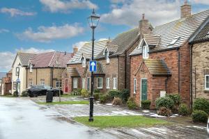 a row of brick houses with a street light at Sandy Toes, The Bay, Filey in Filey