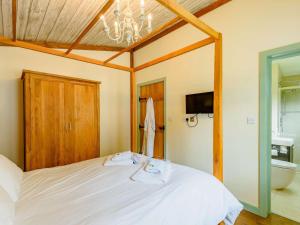 a bedroom with a white bed with a chandelier at 2 Bed in Newark oc-88427 in Walesby
