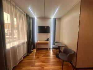 a room with two chairs and a table and a window at Mandala Hotel Erdenet in Erdenet