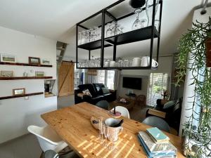 a kitchen and living room with a wooden table and chairs at "ZeeLandZon" Holiday home by the lake with Jacuzzi and Sauna in Herkingen