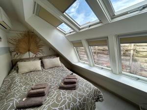 a bedroom with a bed with pillows and windows at "ZeeLandZon" Holiday home by the lake with Jacuzzi and Sauna in Herkingen +28 photos