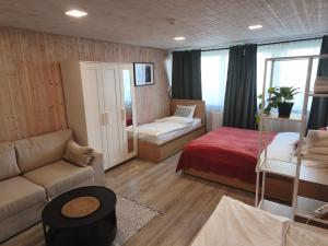 a living room with a bed and a couch and a room with a bed sqor at City Center Hostel in Mažeikiai +29 photos