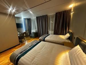 a hotel room with two beds and a desk at Mandala Hotel Erdenet in Erdenet