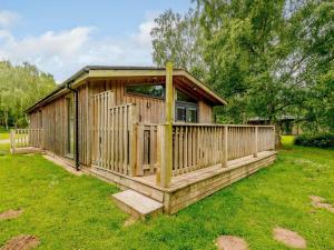 a wooden cabin with a deck in the grass at 2 Bed in Newark oc-88428 in Walesby
