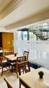 a restaurant with tables and chairs and a large window at Intercity Tower Hotels in San Pedro Sula