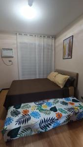 a bedroom with a bed with a flower patterned blanket at Manila Bay City Lights in Manila