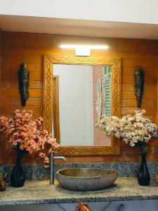 a bathroom with a sink and a mirror and flowers at VILLA De OMR, Private Pool Villa at Old Mahabalipuram Road, Chennai in Kelambākkam +7 photos