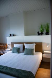 a bedroom with a bed with two plants on the wall at De Horizon in de Westhoek in Poperinge