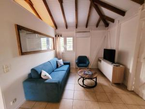 a living room with a blue couch and a tv at Ti Kaz Robin in Trois-Rivières