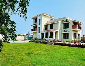a house with a green lawn in front of it at VILLA De OMR, Private Pool Villa at Old Mahabalipuram Road, Chennai in Kelambākkam