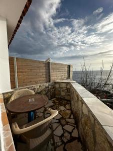 a patio with a table and chairs on a balcony at Beleris Rooms in Himare