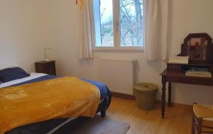 a bedroom with a bed and a desk and a window at Las Irondas in Moissac