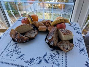 a plate of bread and fruit on a table at Les chambres de Noëlla in LʼAiguillon-sur-Vie