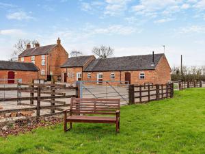 a bench sitting in the grass in front of a building at 3 Bed in Ashbourne oc-94309 in Windley
