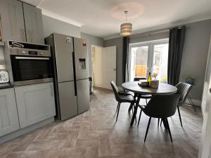 a kitchen with a table with chairs and a refrigerator at 3 bed house in Risca in Risca