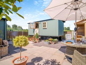 a tiny house in a garden with an umbrella at 1 Bed in Leominster oc-93060 in Pembridge