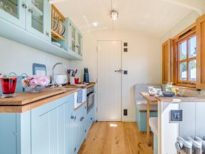 a kitchen with blue cabinets and a wooden floor at 1 Bed in Leominster oc-93060 in Pembridge