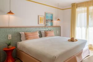 a bedroom with a large white bed with orange pillows at Appartements Soléo Prado in Marseille