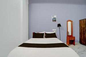 a bedroom with a white bed with black pillows at Super Hotel Redmoon Residency Elite in Chennai +21 photos