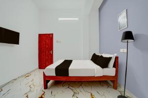 a bedroom with a bed and a red door at Super Hotel Redmoon Residency Elite in Chennai