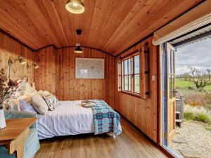 a bedroom with a bed in a wooden wall at 1 Bed in Lutterworth oc-93761 in Boughton