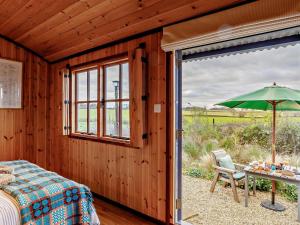 a bedroom with a bed and a table with an umbrella at 1 Bed in Lutterworth oc-93761 in Boughton