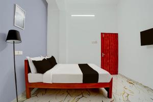 a bedroom with a bed and a red door at Super Hotel Redmoon Residency Elite in Chennai