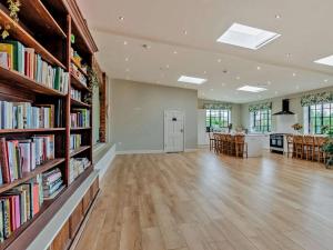 a large room with bookshelves and a room with a kitchen at 1 Bed in Lutterworth oc-93760 in Boughton