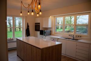 a kitchen with a large island in the middle of it at De Horizon in de Westhoek in Poperinge